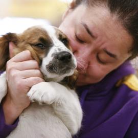 woman hugging small dog